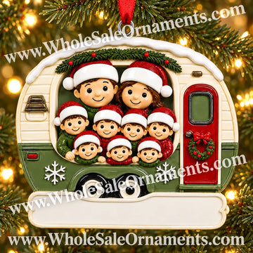 Family of nine Christmas camper ornament in cream and green with red door and blank plaque, hanging on a Christmas tree with warm lights